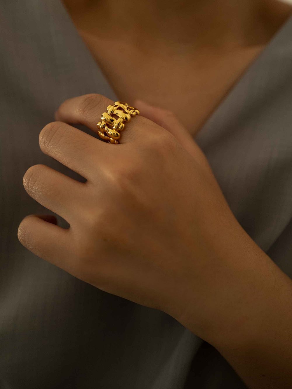 a hand wear A gold ring with a woven pattern
