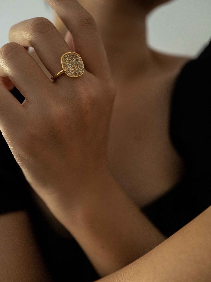 a hand wear One square zirconia-set gold-colored ring
