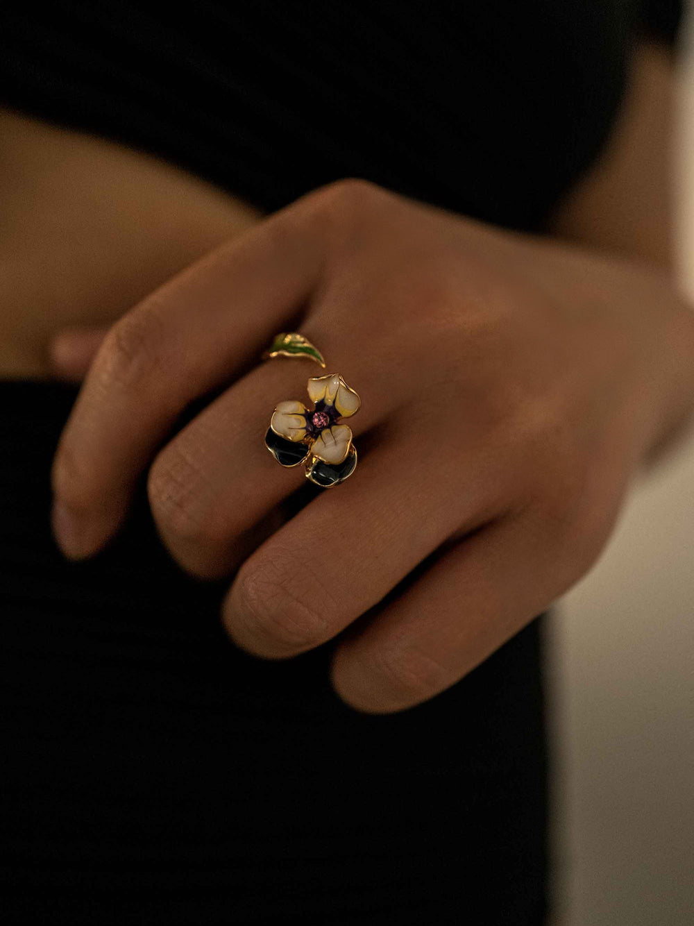 a hand wear A cold enameled floral and leaf ring.