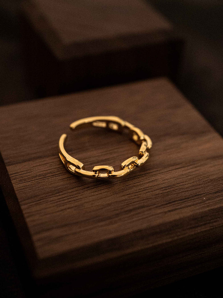 A gold ring with a chain design