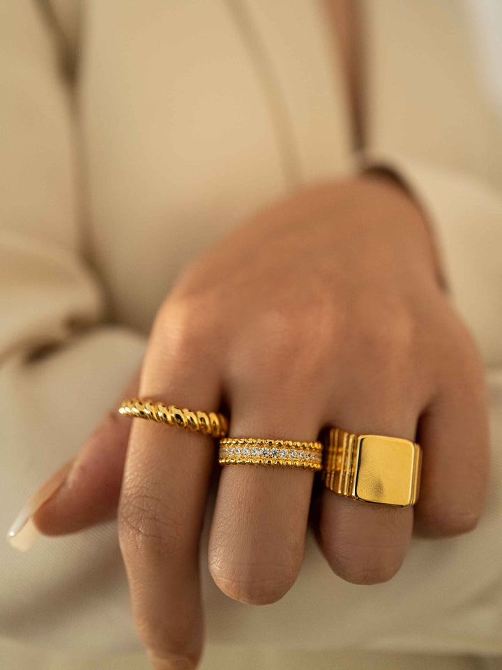 a hand wear A gold twist ring.