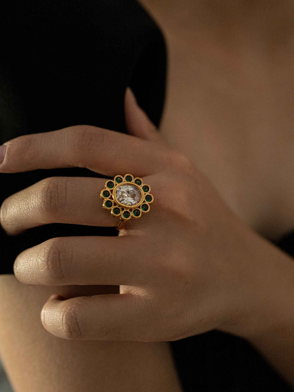a hand wear Gold ring with green and clear zircons