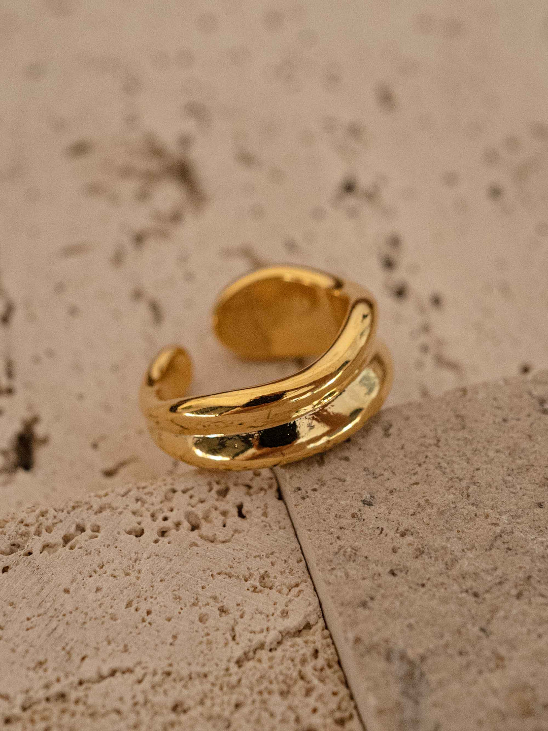 A gold colored irregular ring