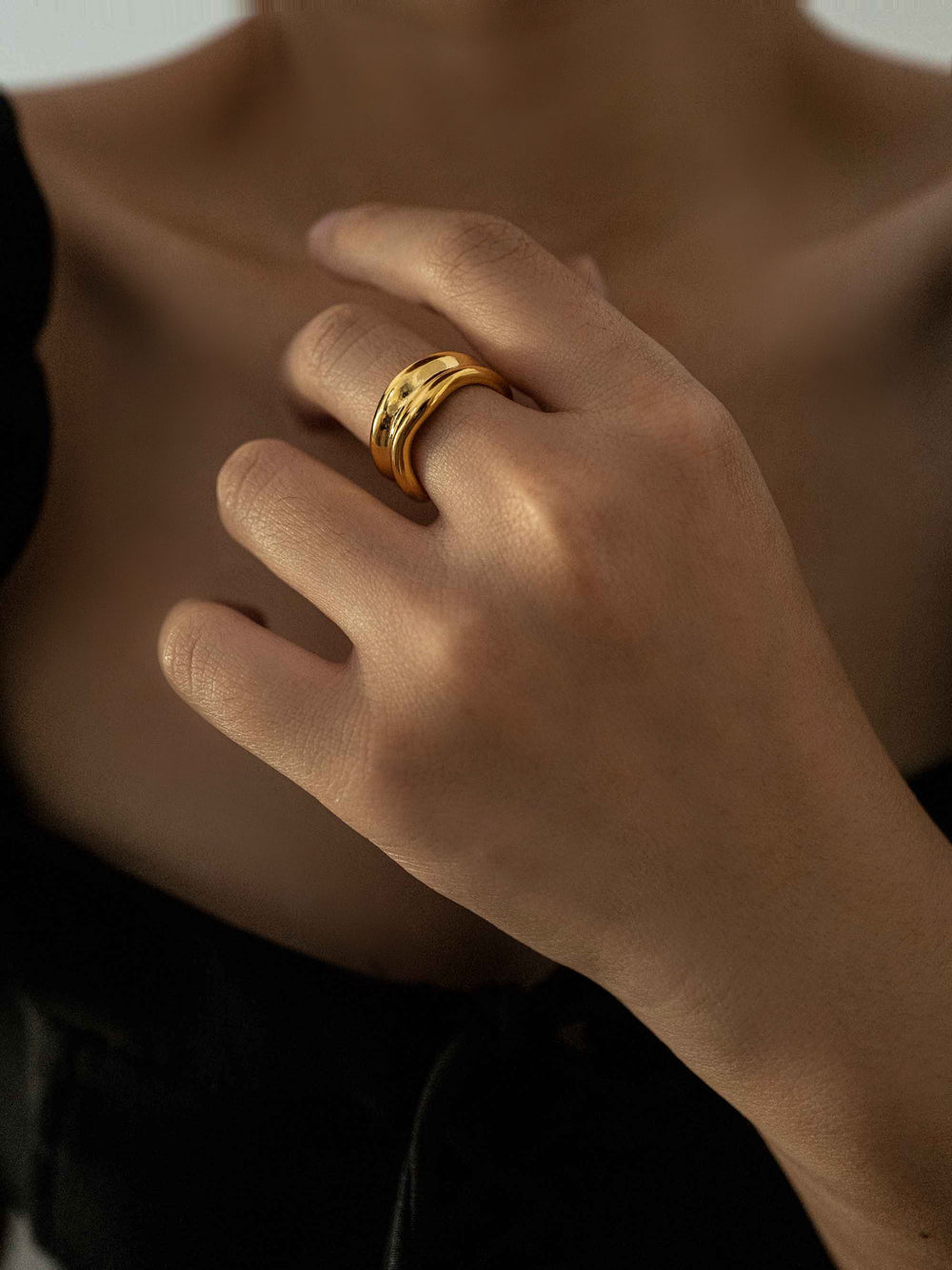 a hand wear A gold colored irregular ring