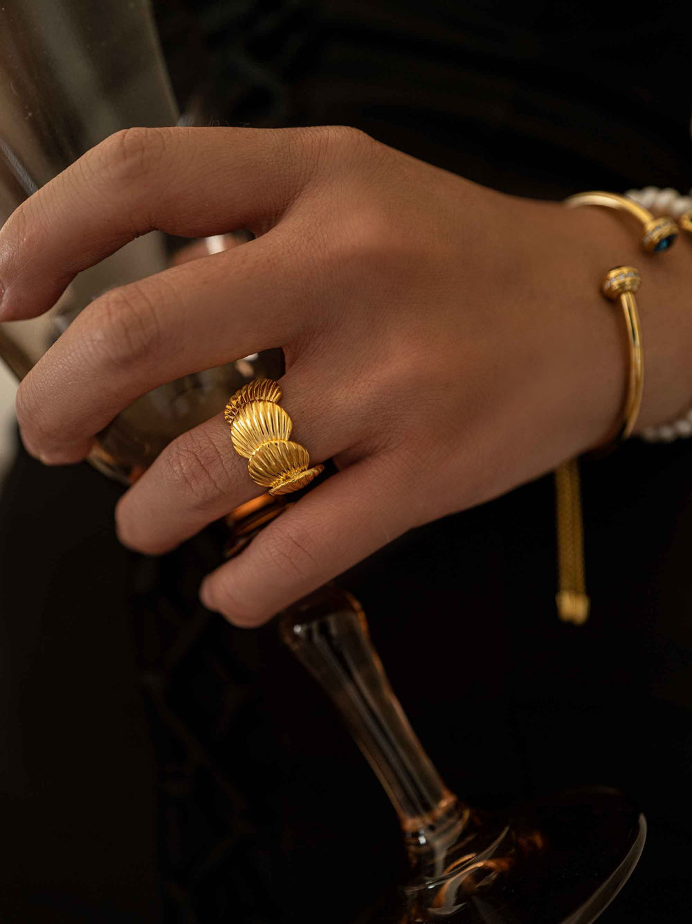 a hand wear A gold ring in the shape of a seashell