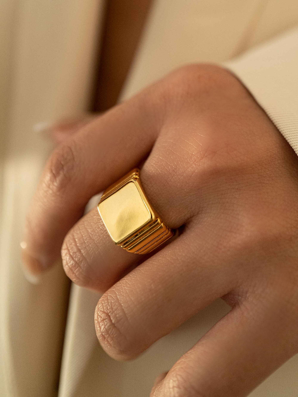 a hand wear A gold geometric square ring