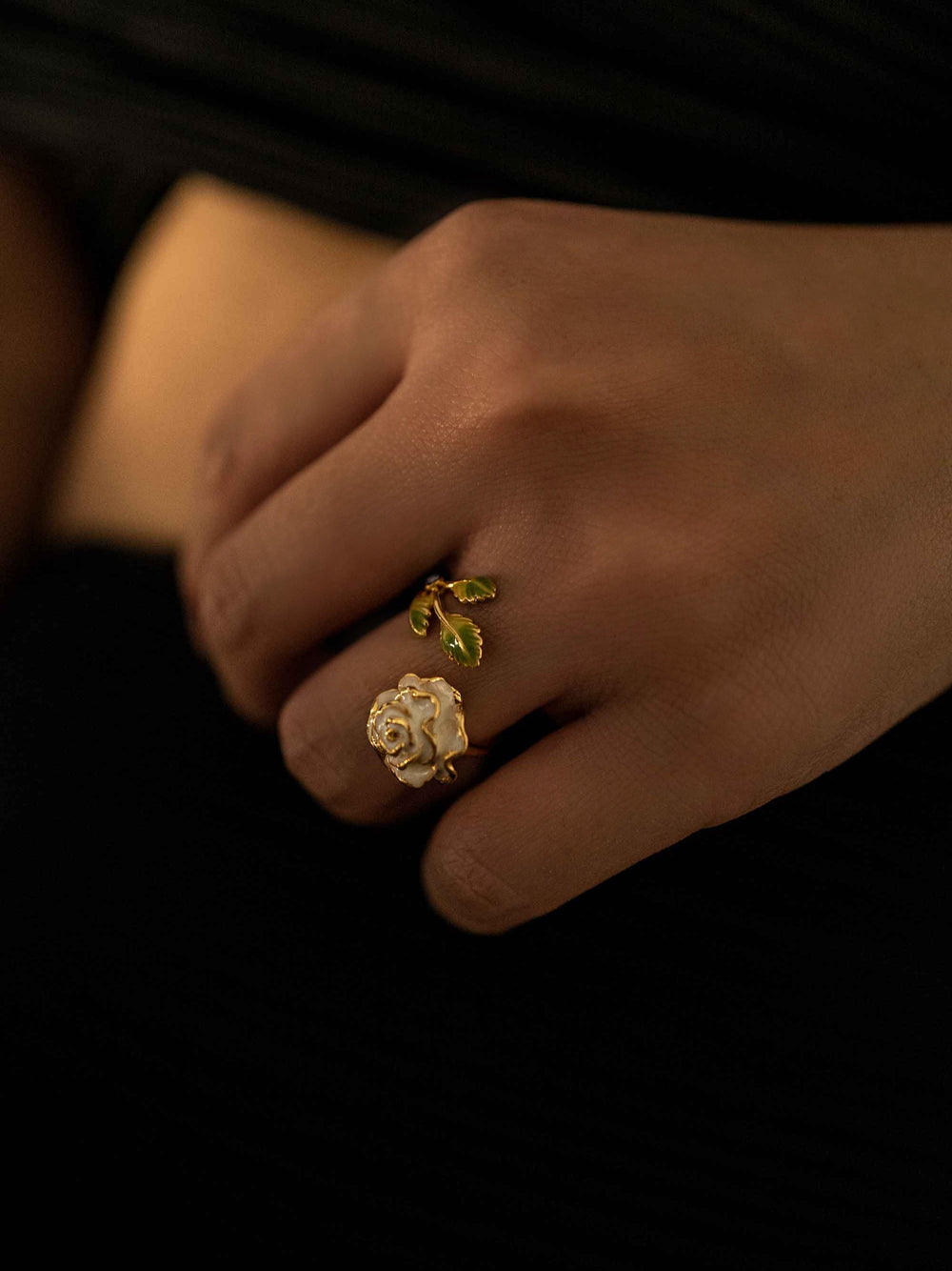 a hand wear A gold rose flower and leaf ring