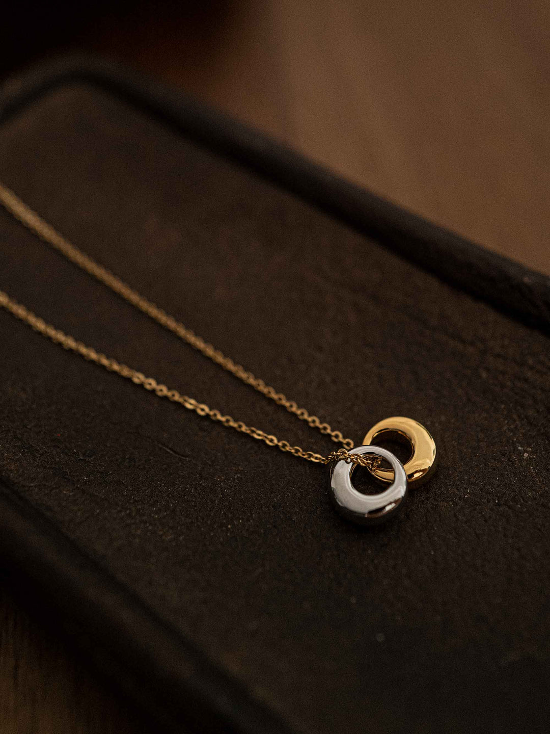 A gold necklace with gold and silver circles