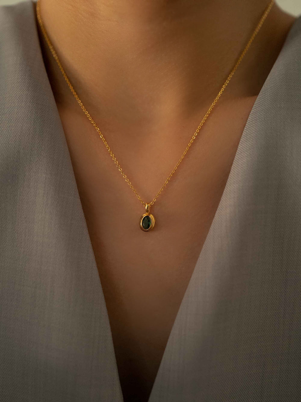 a model wear A mini green crystal oval pendant gold necklace