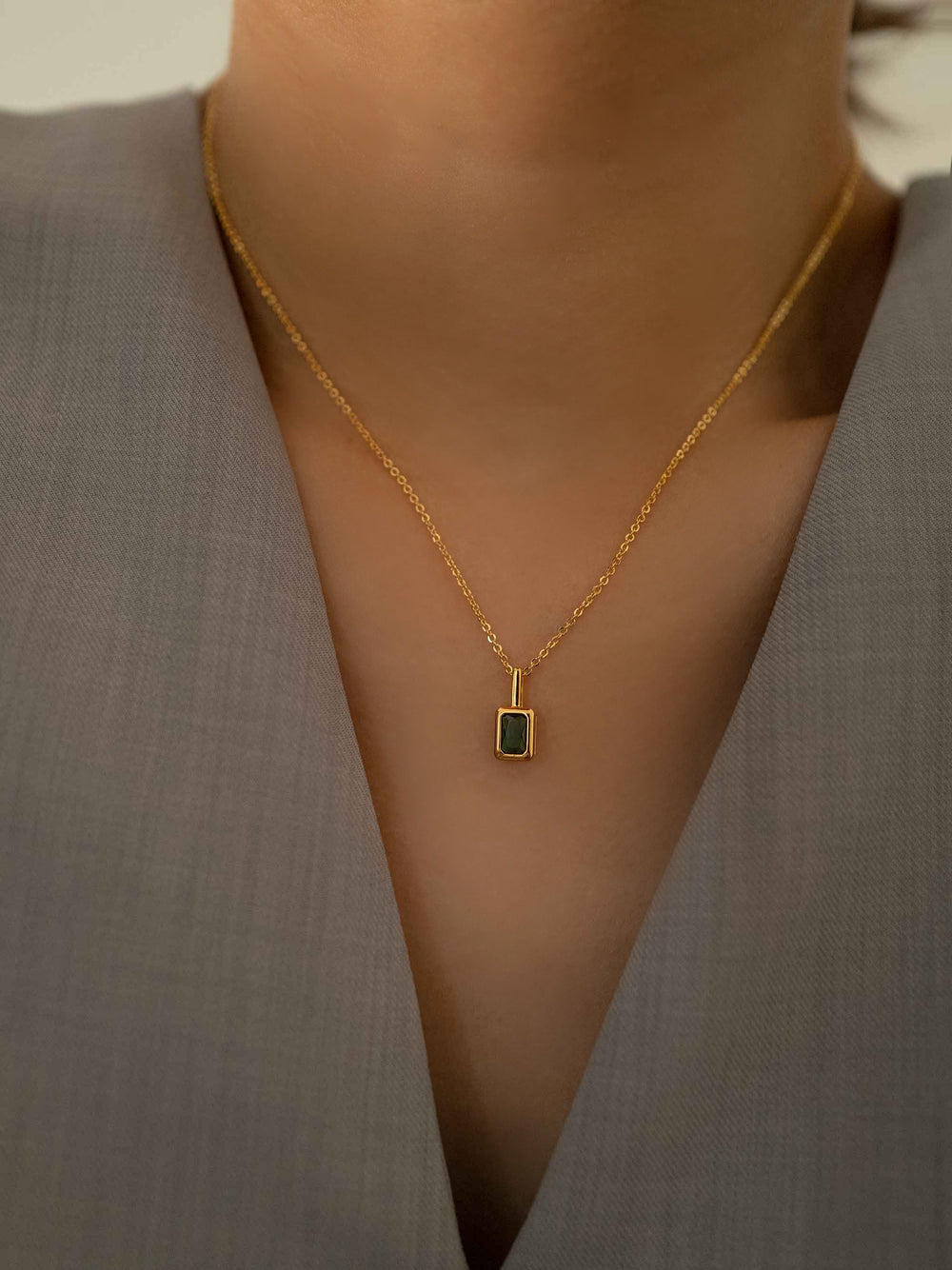 a model wear A mini green crystal pendant gold necklace