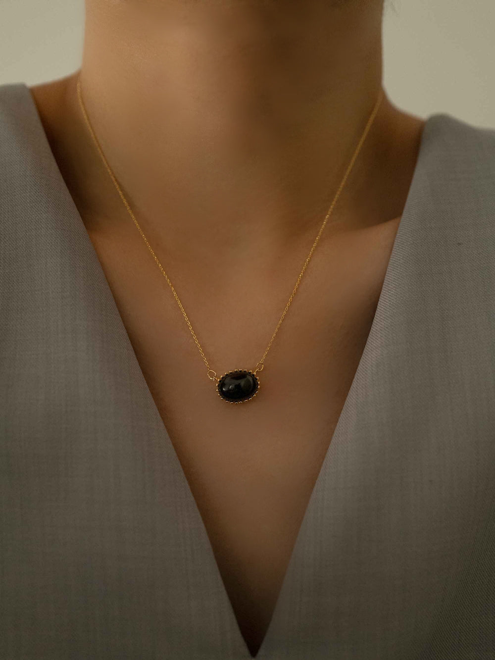a model with A black natural stone gold necklace