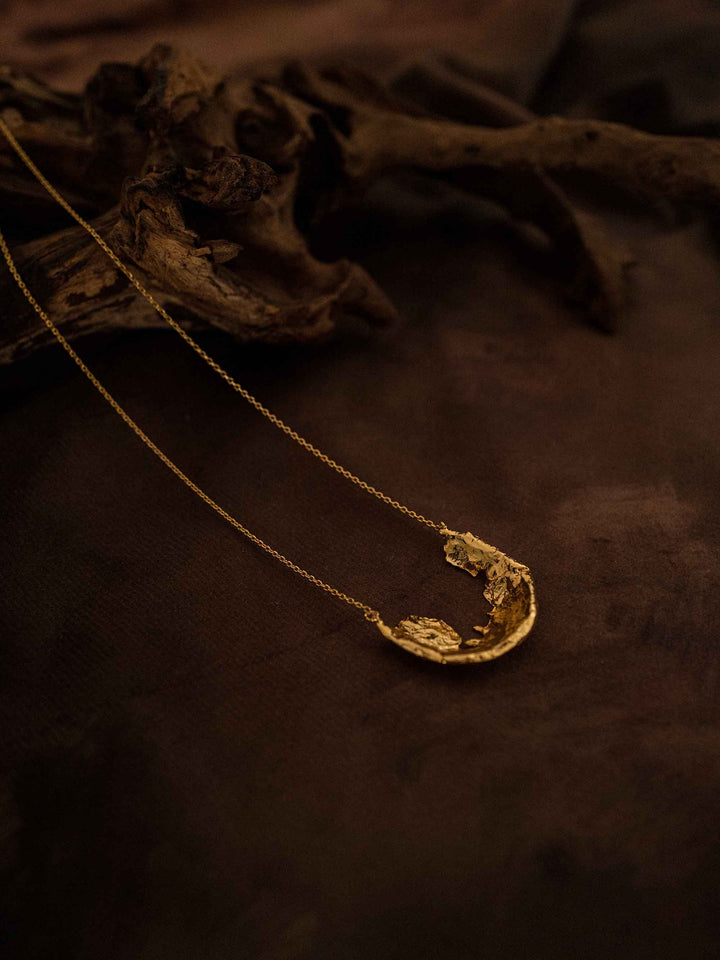 A gold necklace with a fragment pendant