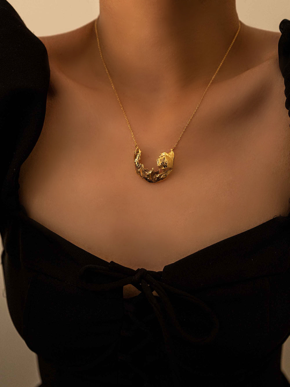 a model wear A gold necklace with a fragment pendant