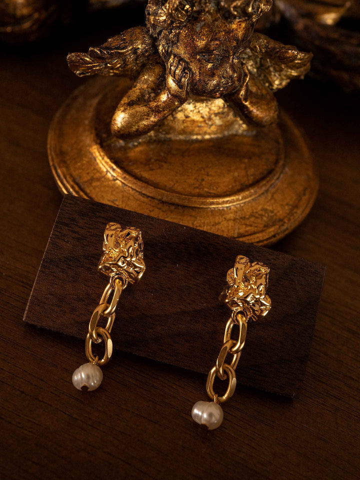 A gold chain earring with cultured pearls dangling from it