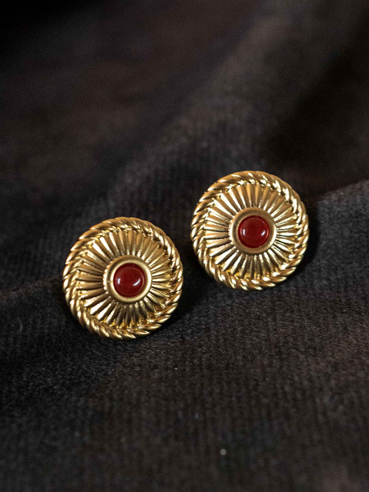 A pair of golden earrings with red crystal agate