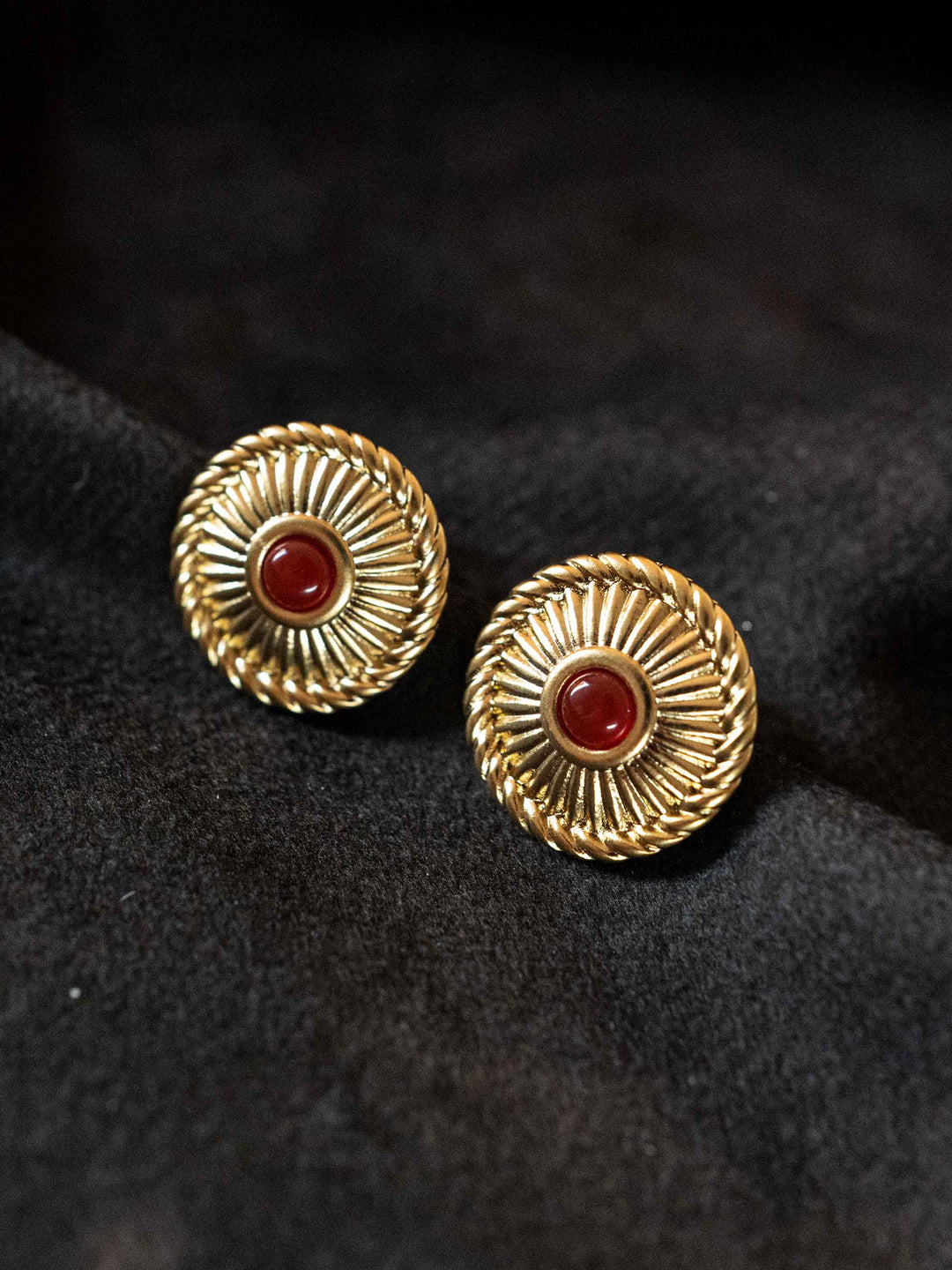 A pair of golden earrings with red crystal agate