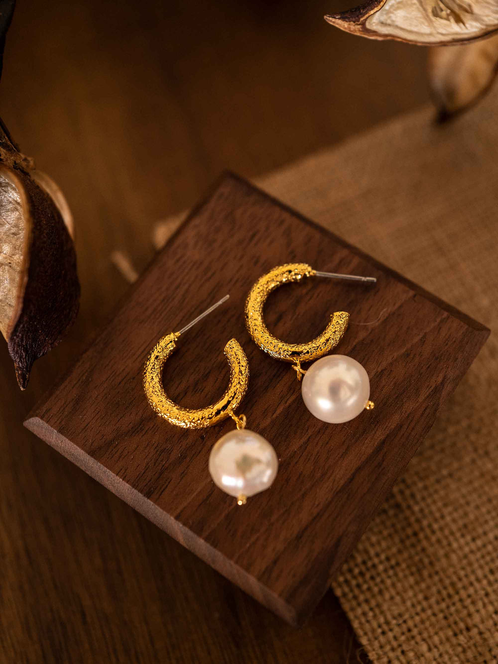 A pair of frosted circle gold pearl earrings