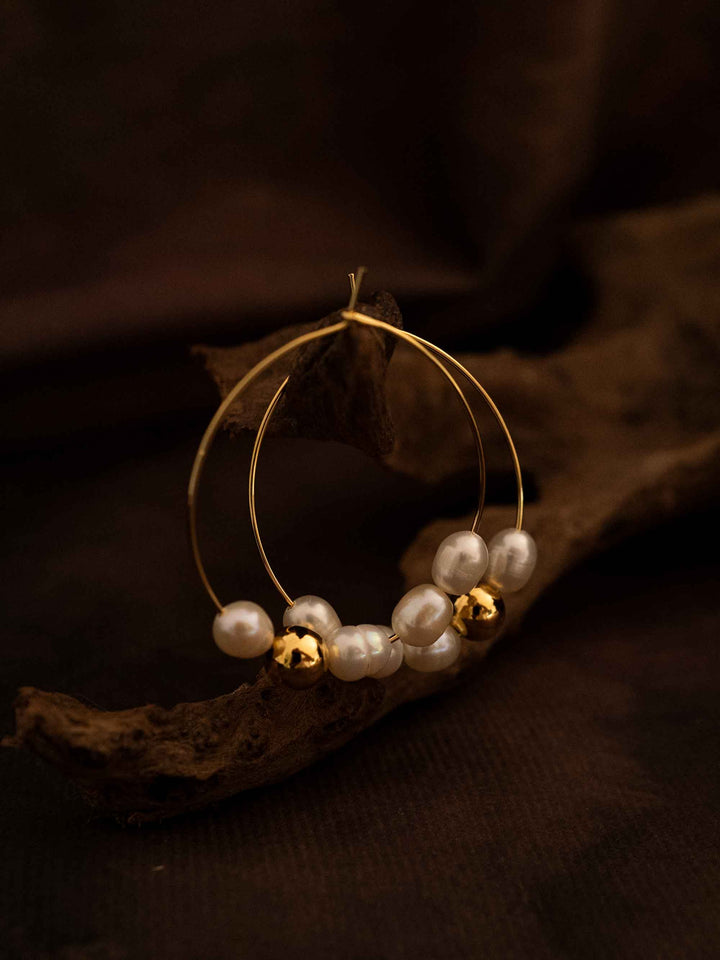 A pair of oval hoop pearl gold earrings