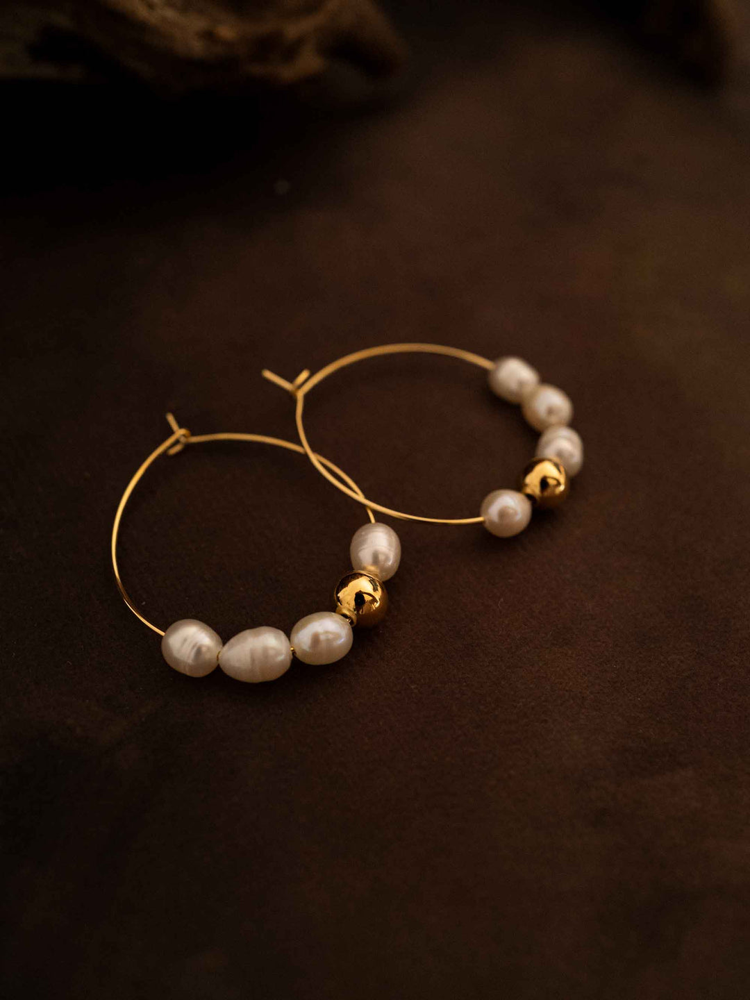 A pair of oval hoop pearl gold earrings