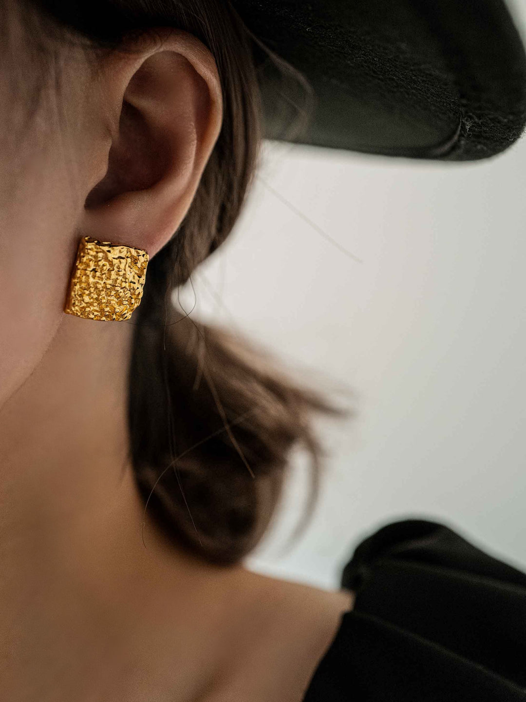 a model wear gold square pleated earrings