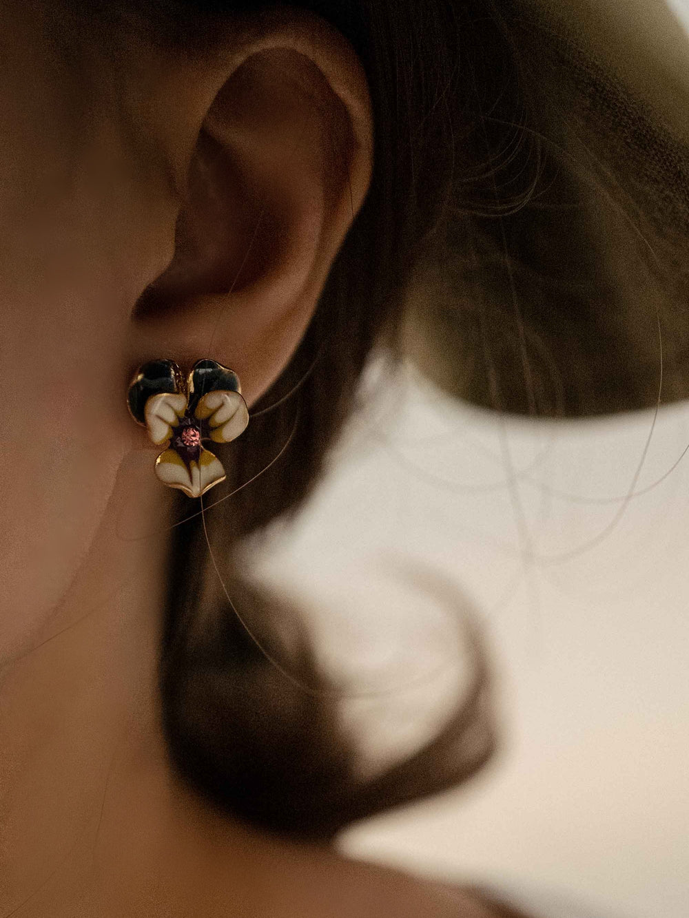 a model wear A cold enameled floral earrings