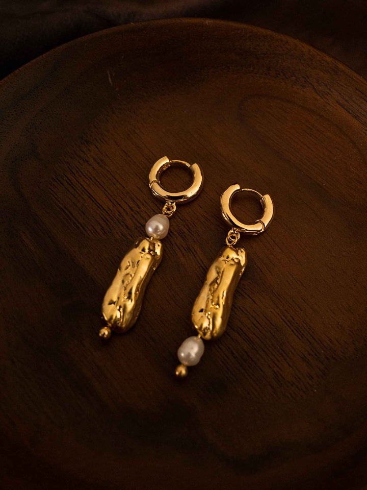 A long asymmetrical pearl gold earrings