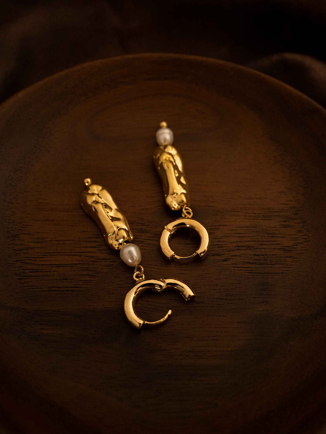 A long asymmetrical pearl gold earrings