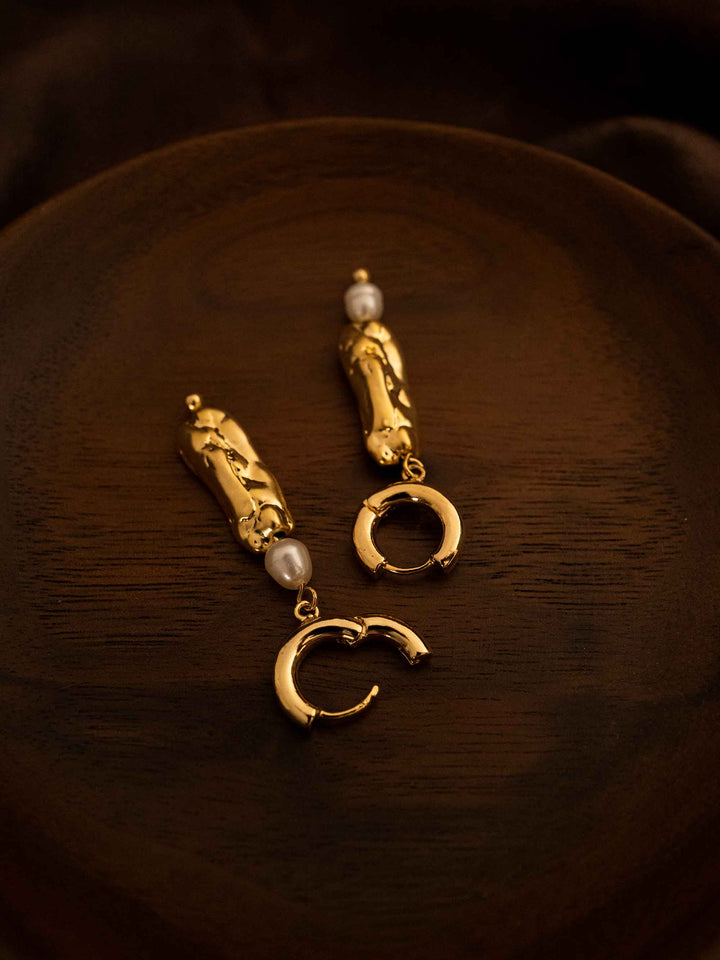 A long asymmetrical pearl gold earrings