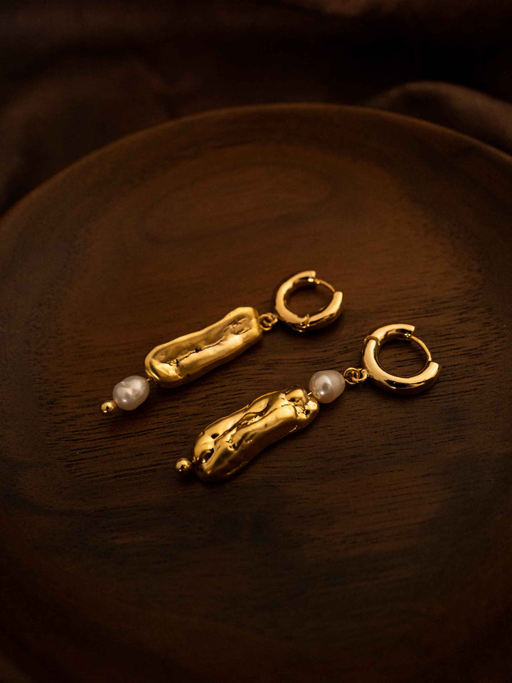 A long asymmetrical pearl gold earrings