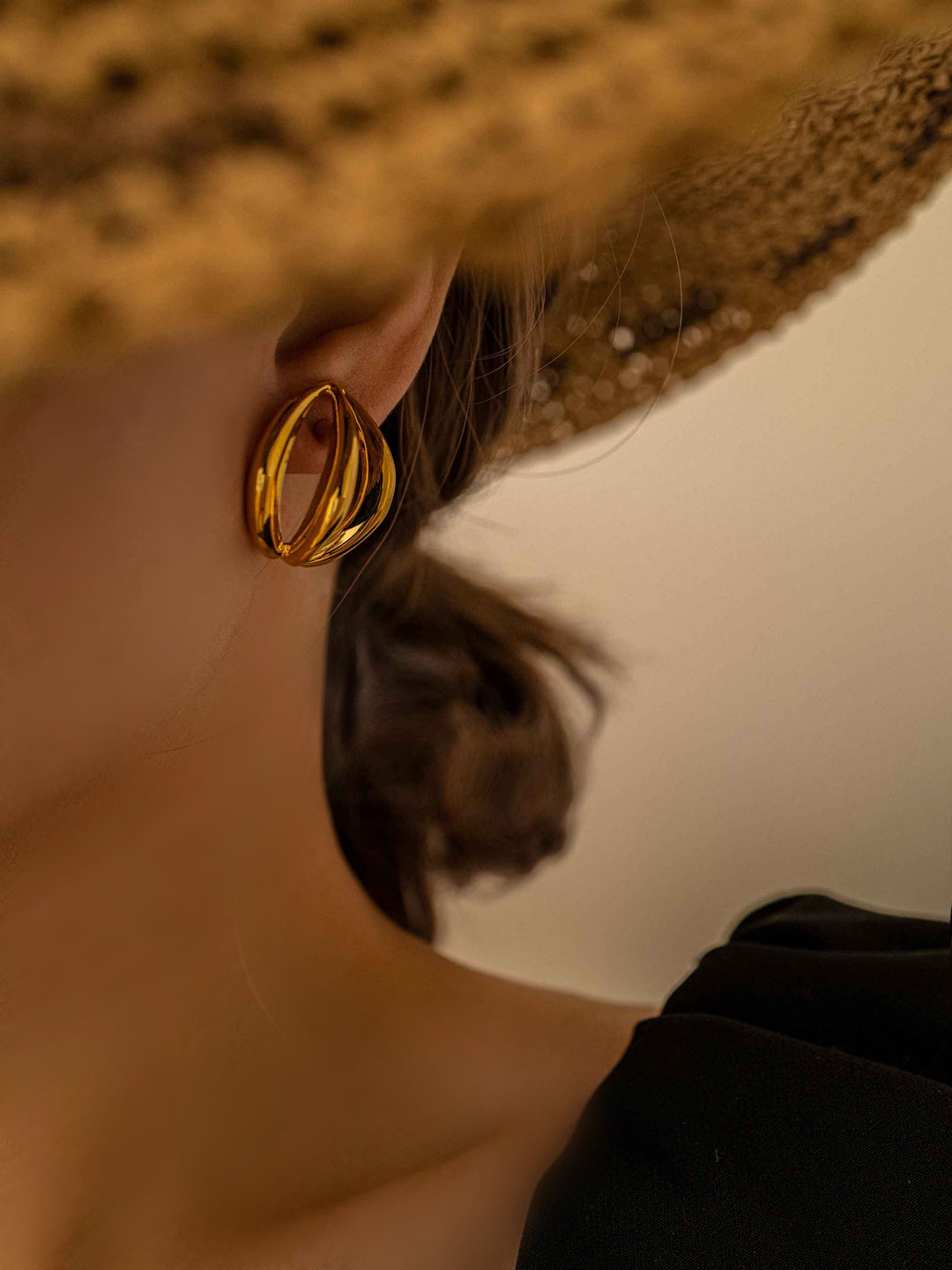 a model wear A gold openwork olive earring