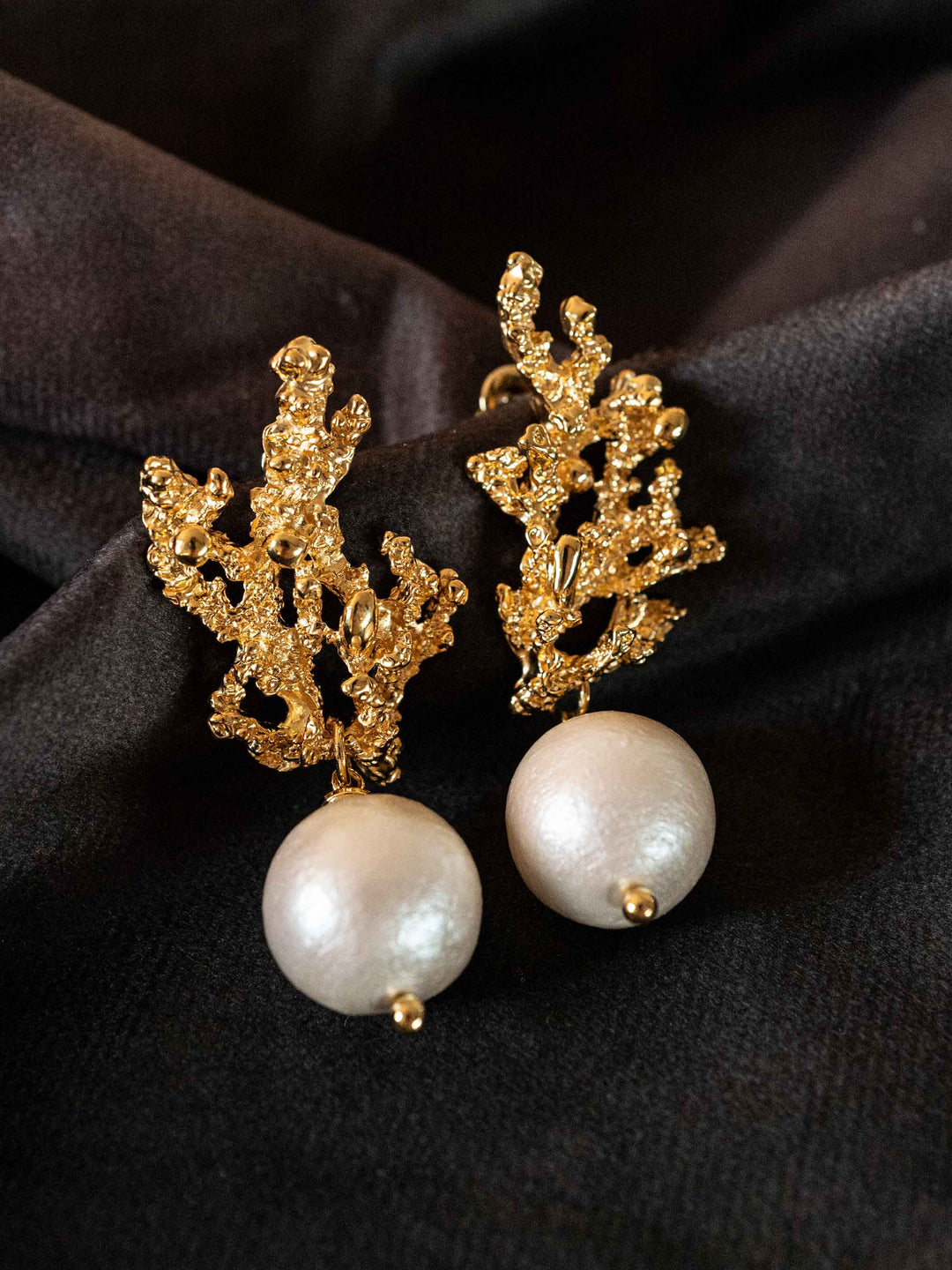 A pair of earrings with golden cotton pearls