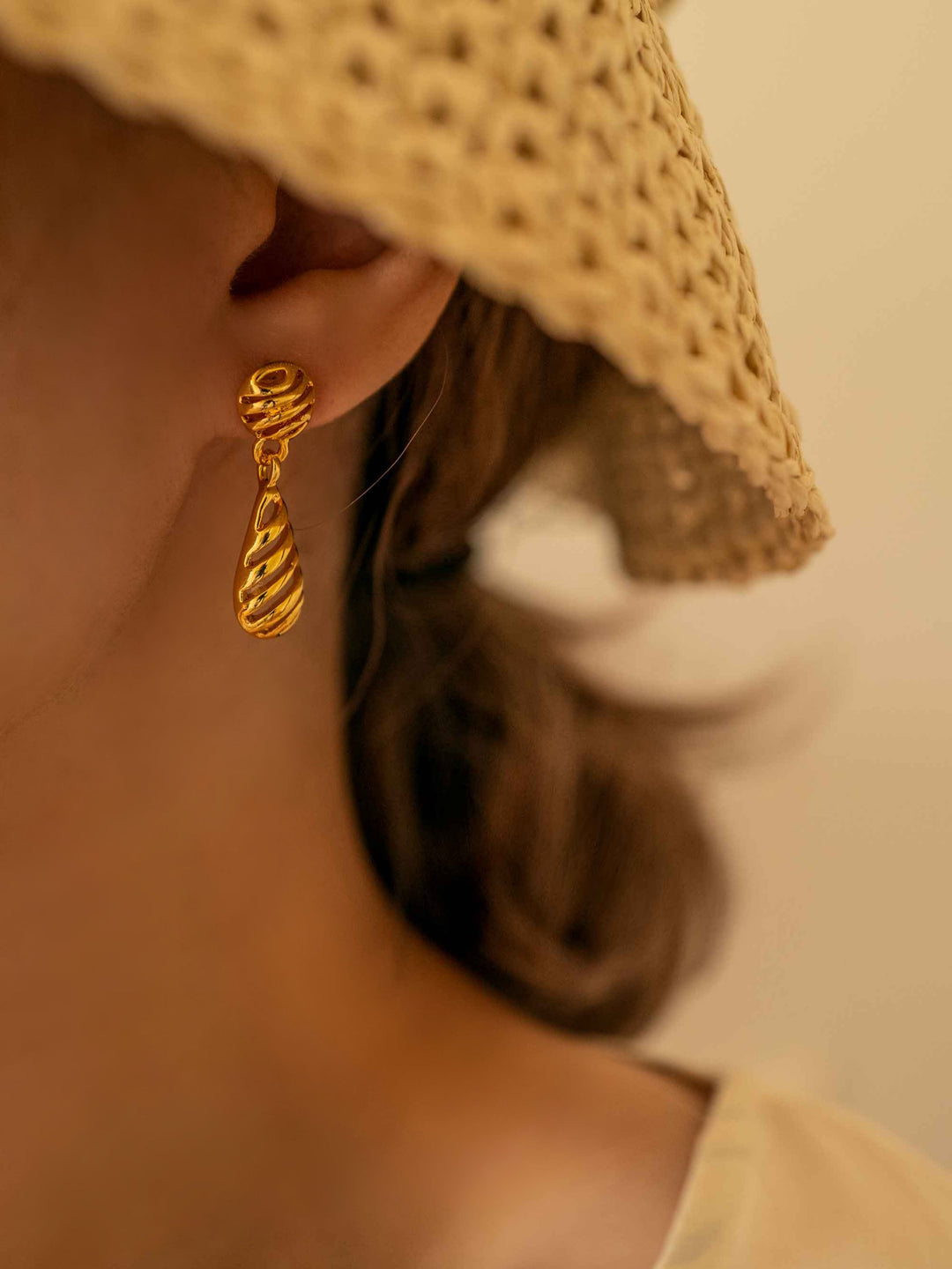 a model wear Openwork round drop-shaped gold earrings