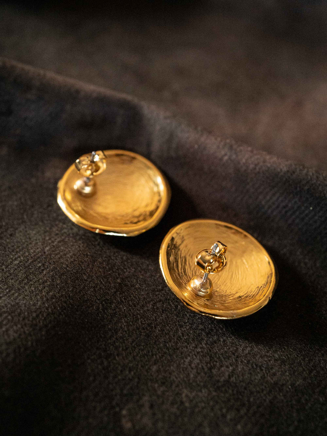 A pair of round gold earrings