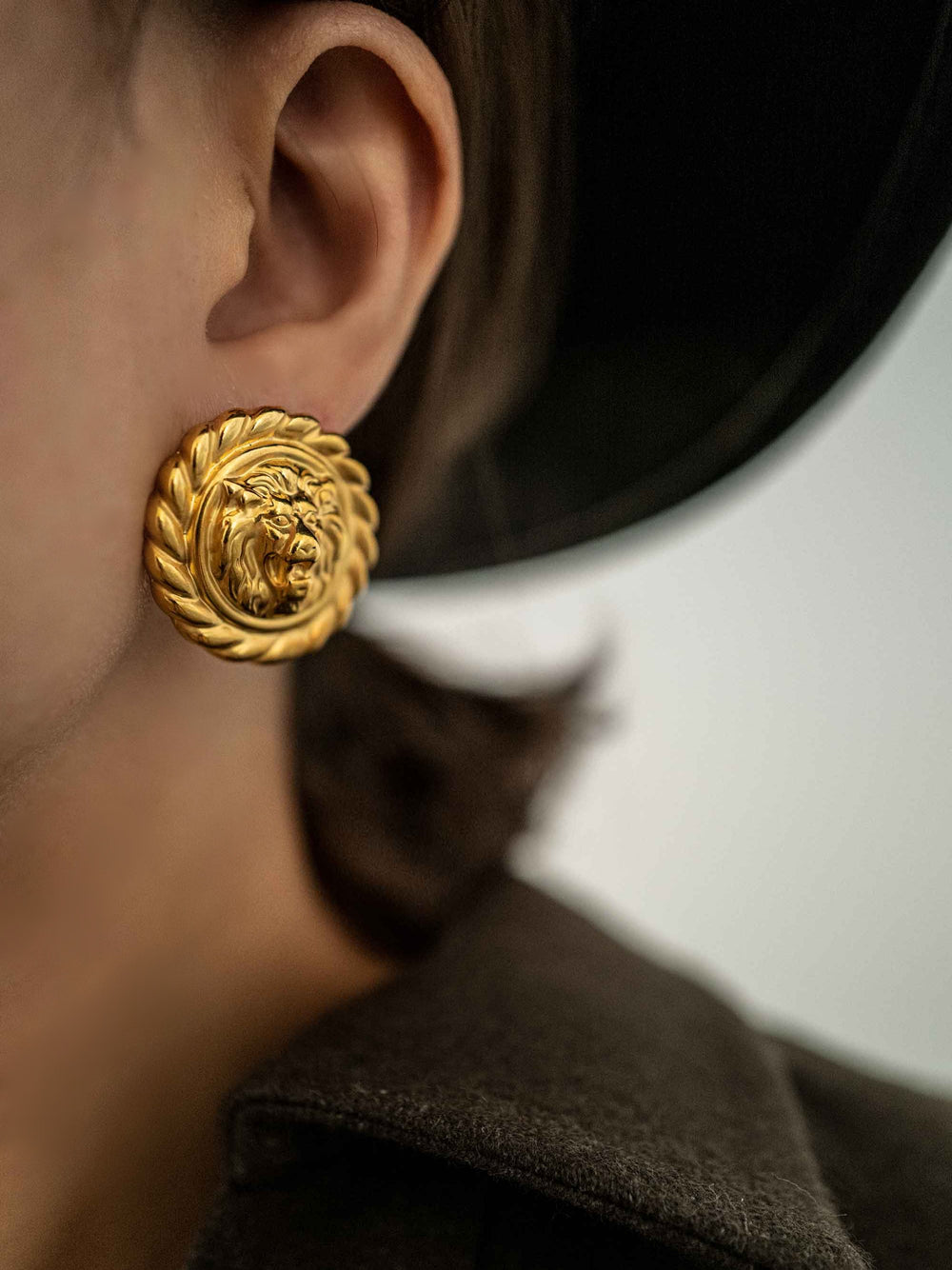 a model wear A golden round earring