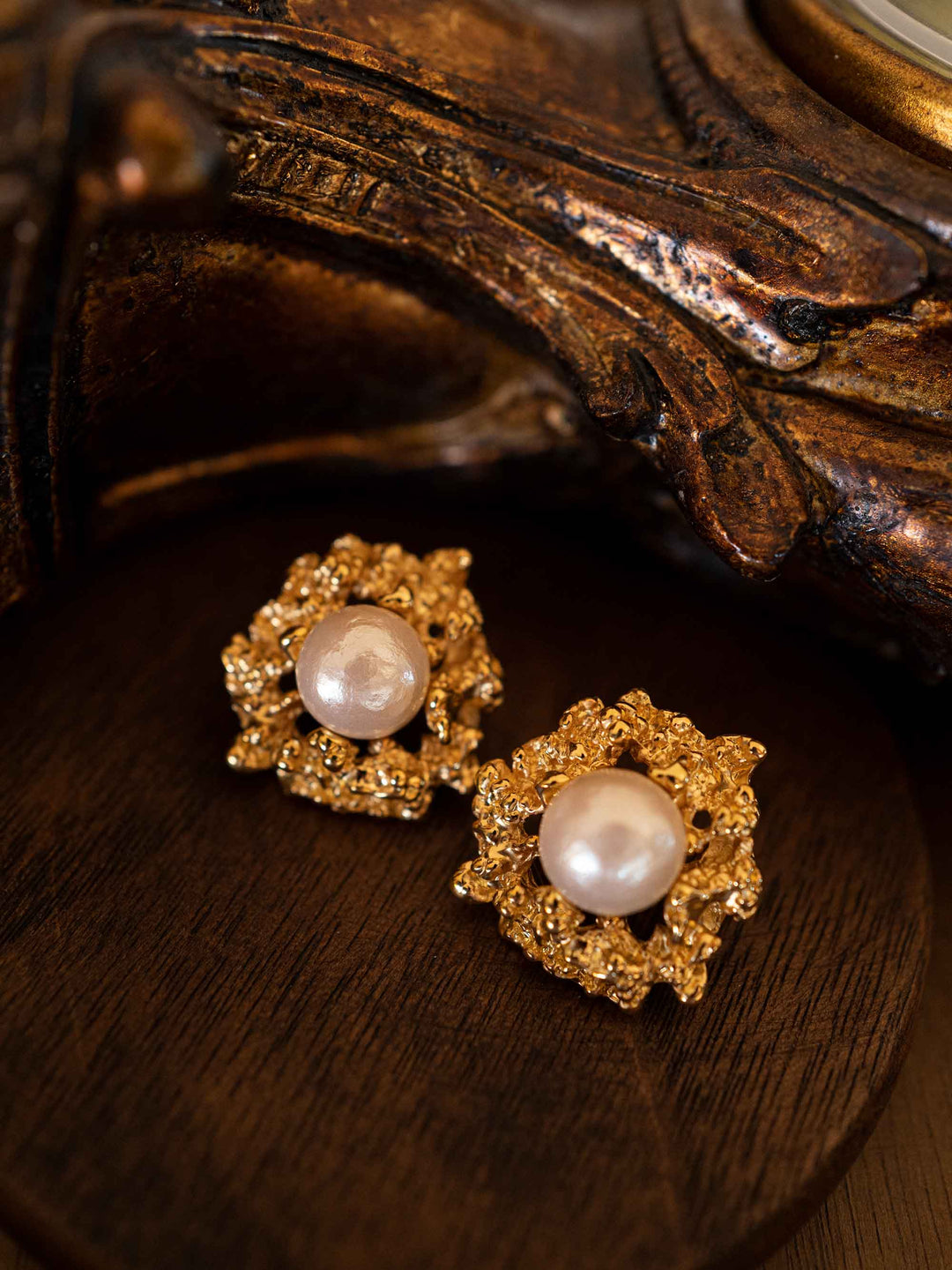A pair of gold earrings with cotton pearls