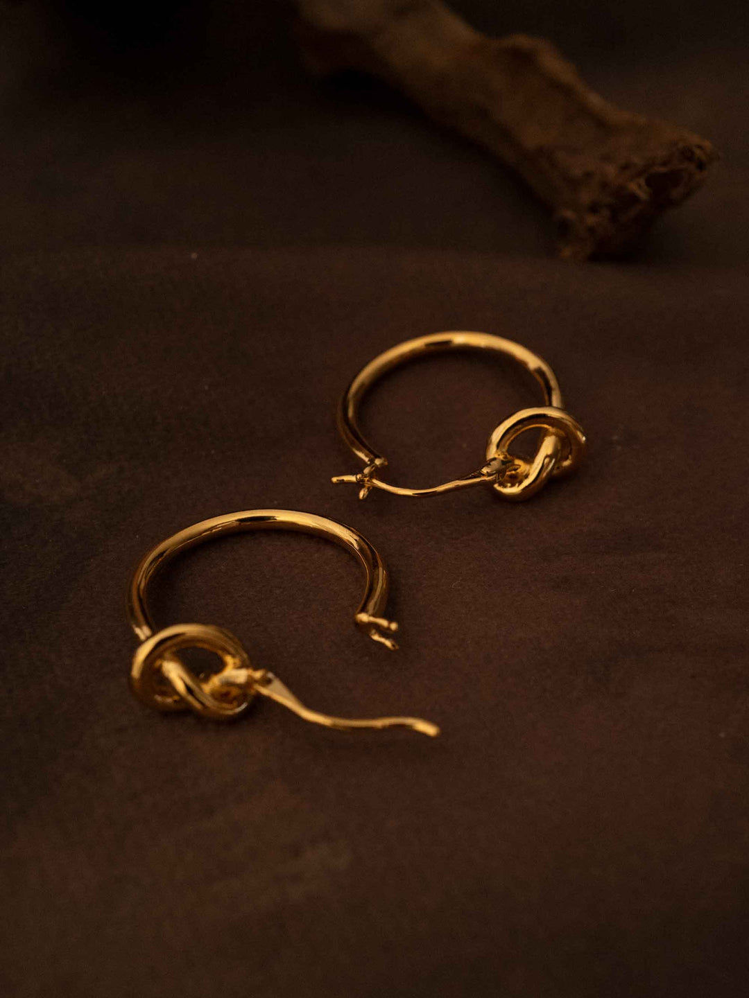 A hoop of gold earrings with a love knot