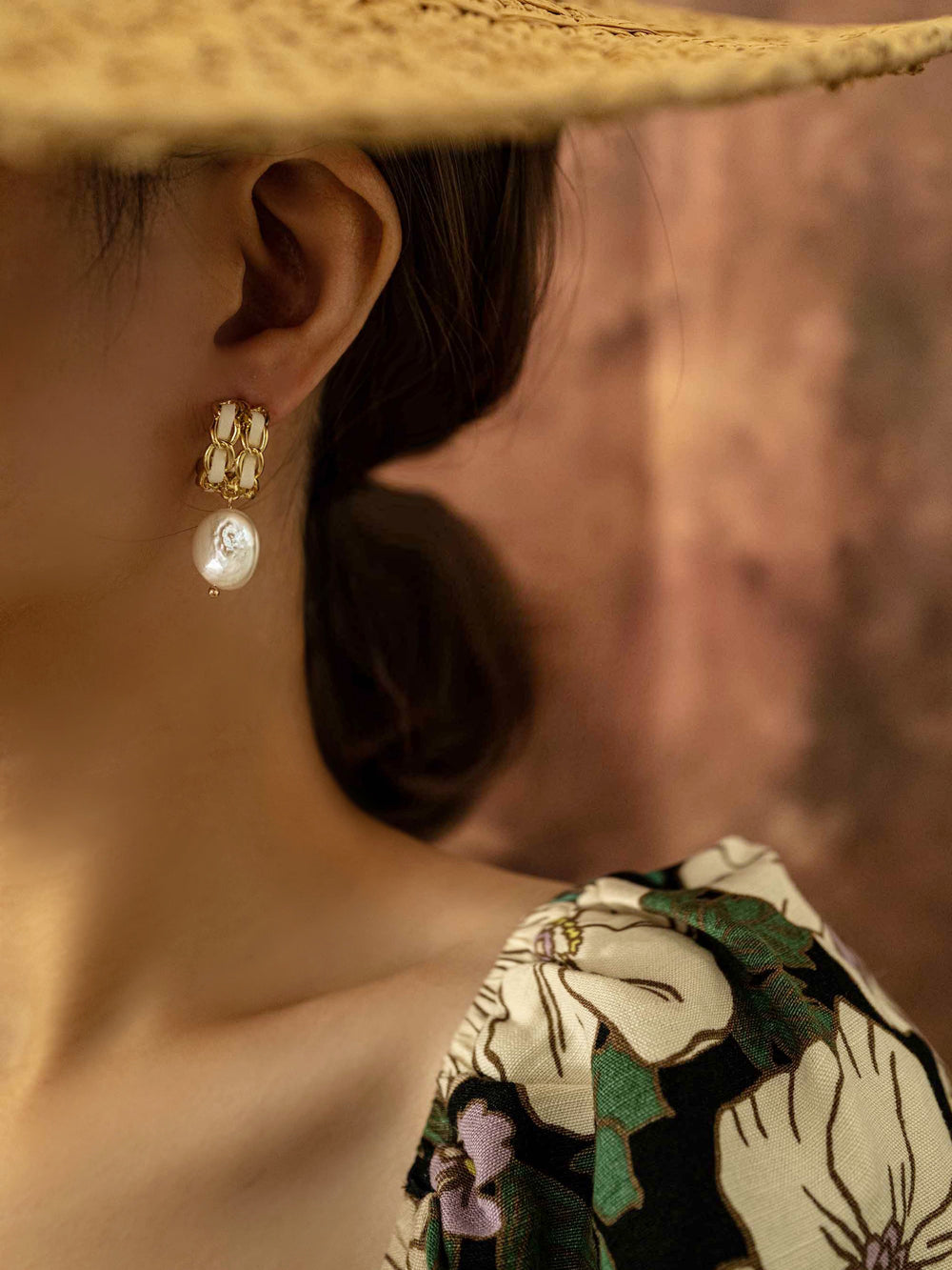 a model wear A  baroque pearl gold earring with white ribbon on a grid