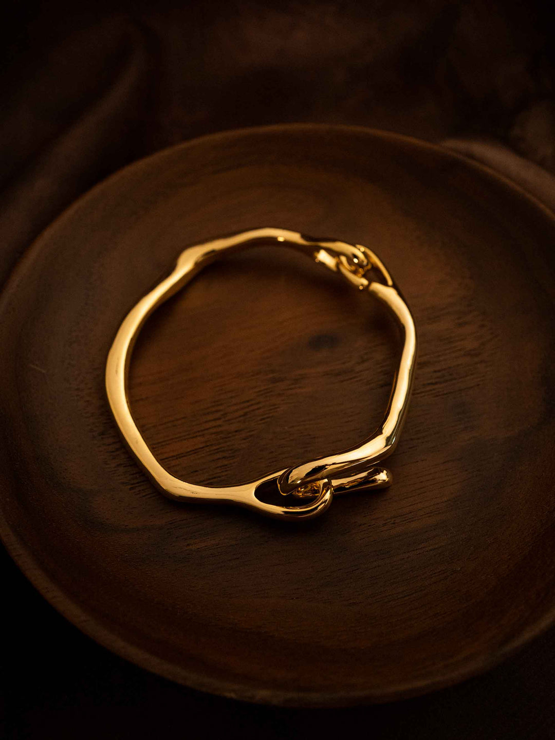 A gold bracelet with a gold hook closure