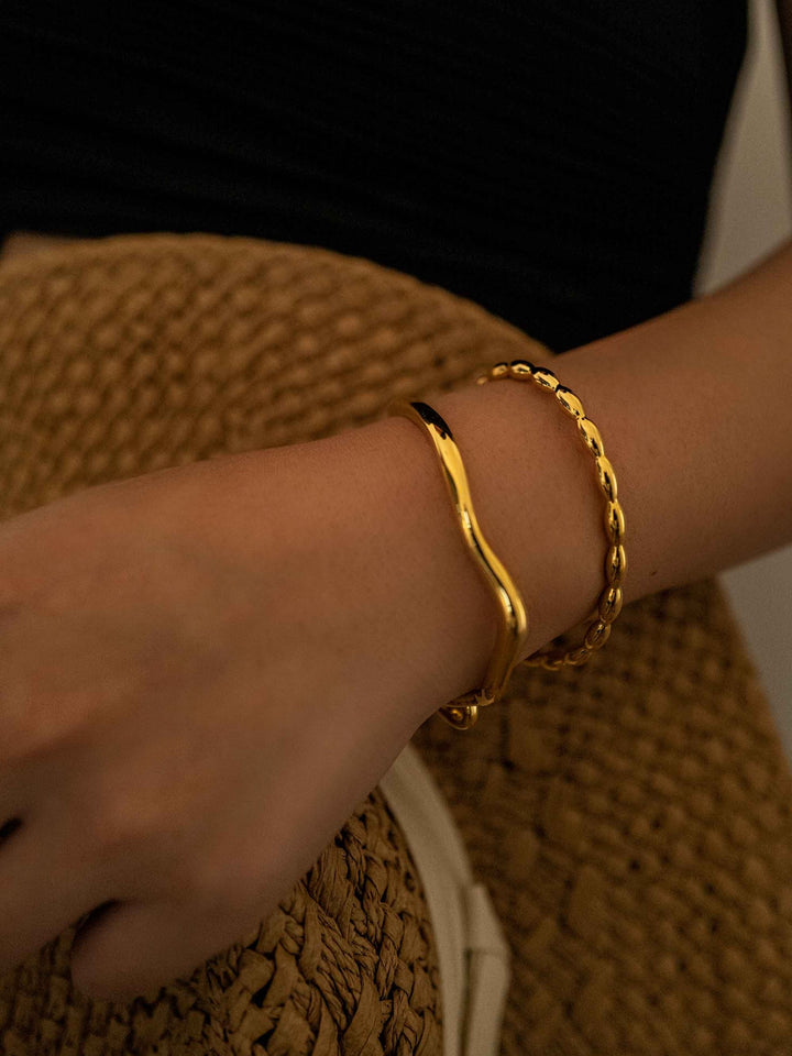 a hand wear A gold bracelet with a gold hook closure