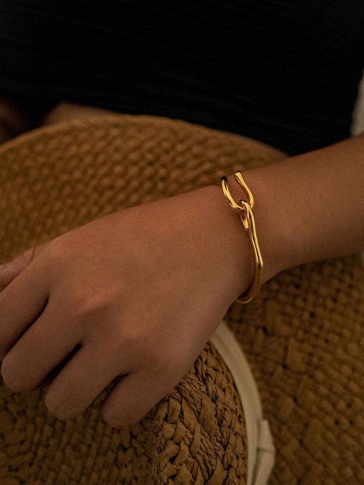 a hand wear A gold bracelet with a gold hook closure