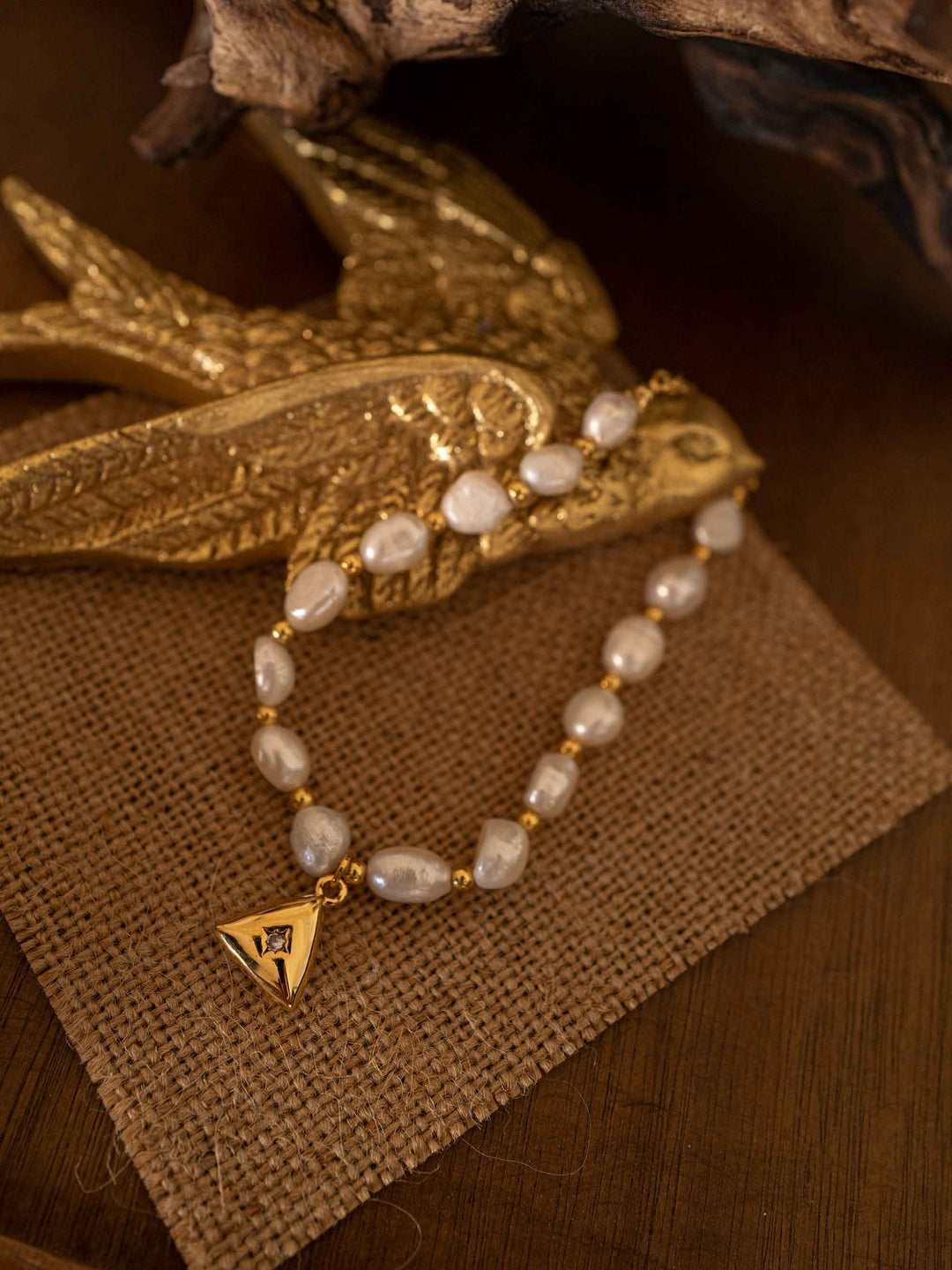 A pearl bracelet with a triangular pendant