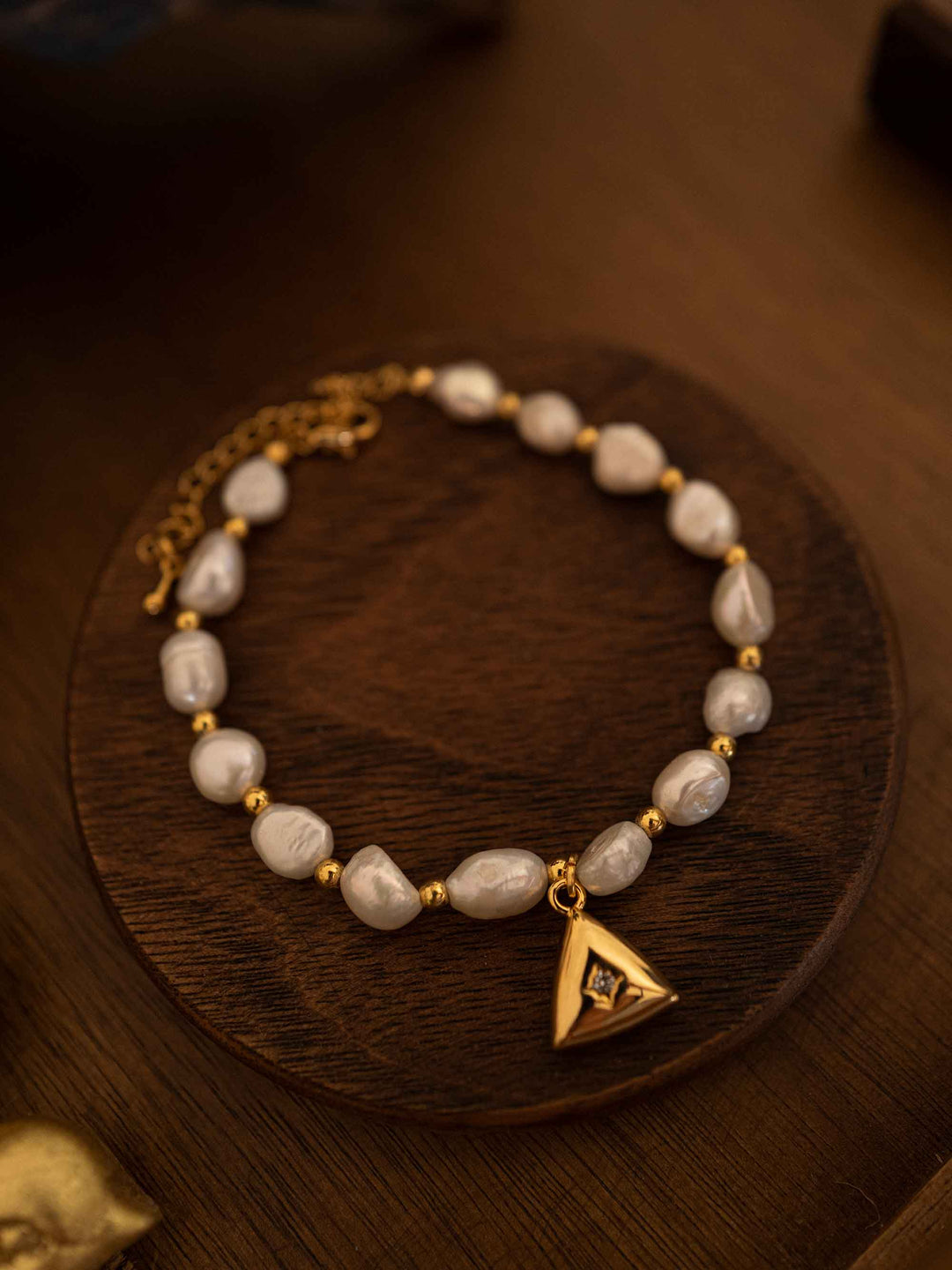 A pearl bracelet with a triangular pendant