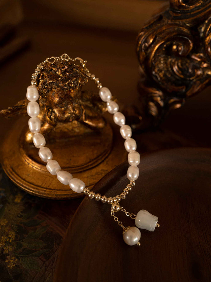 A bracelet of freshwater pearls with a charm of lily of the valley