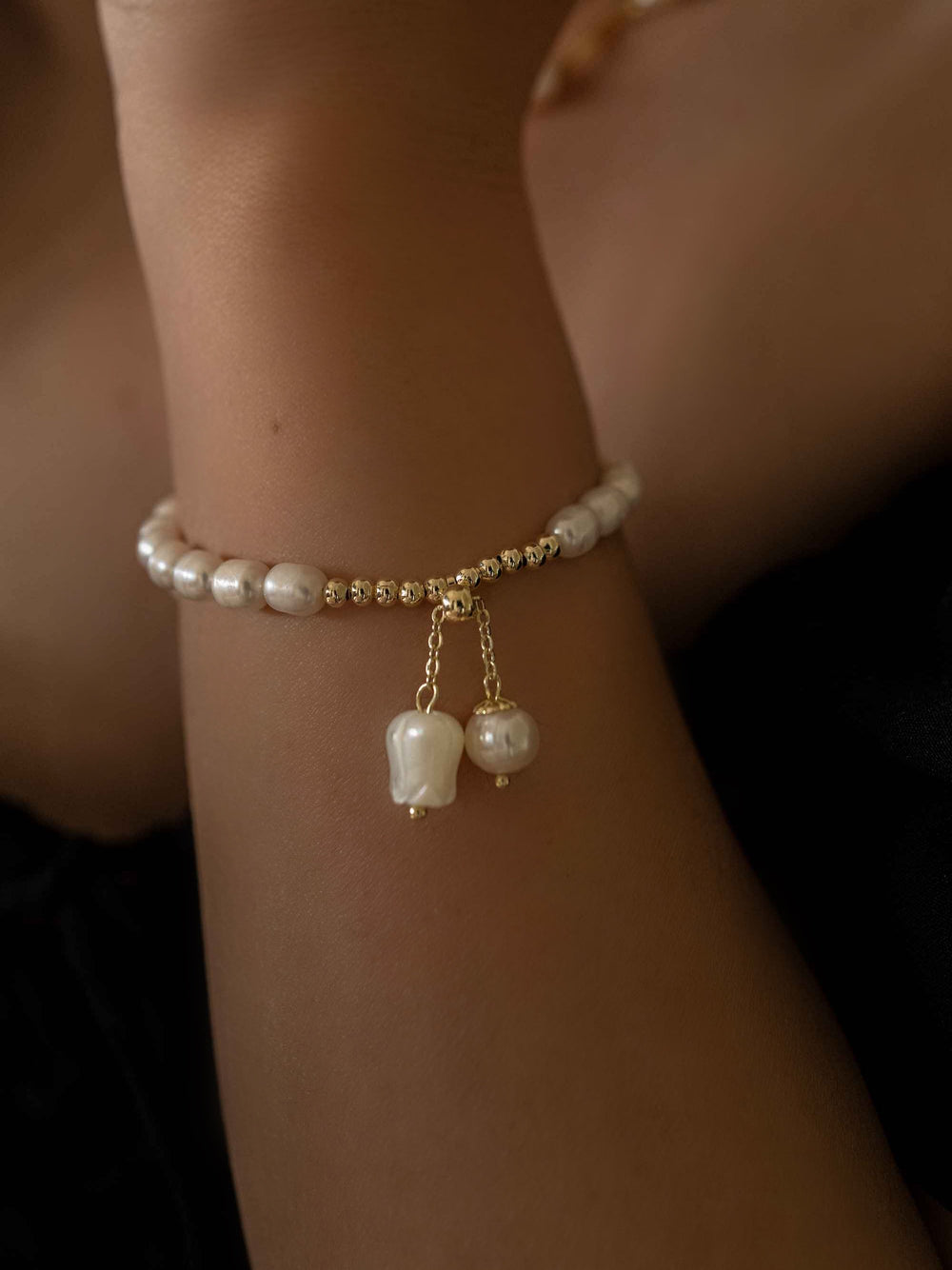 a hand wear A bracelet of freshwater pearls with a charm of lily of the valley