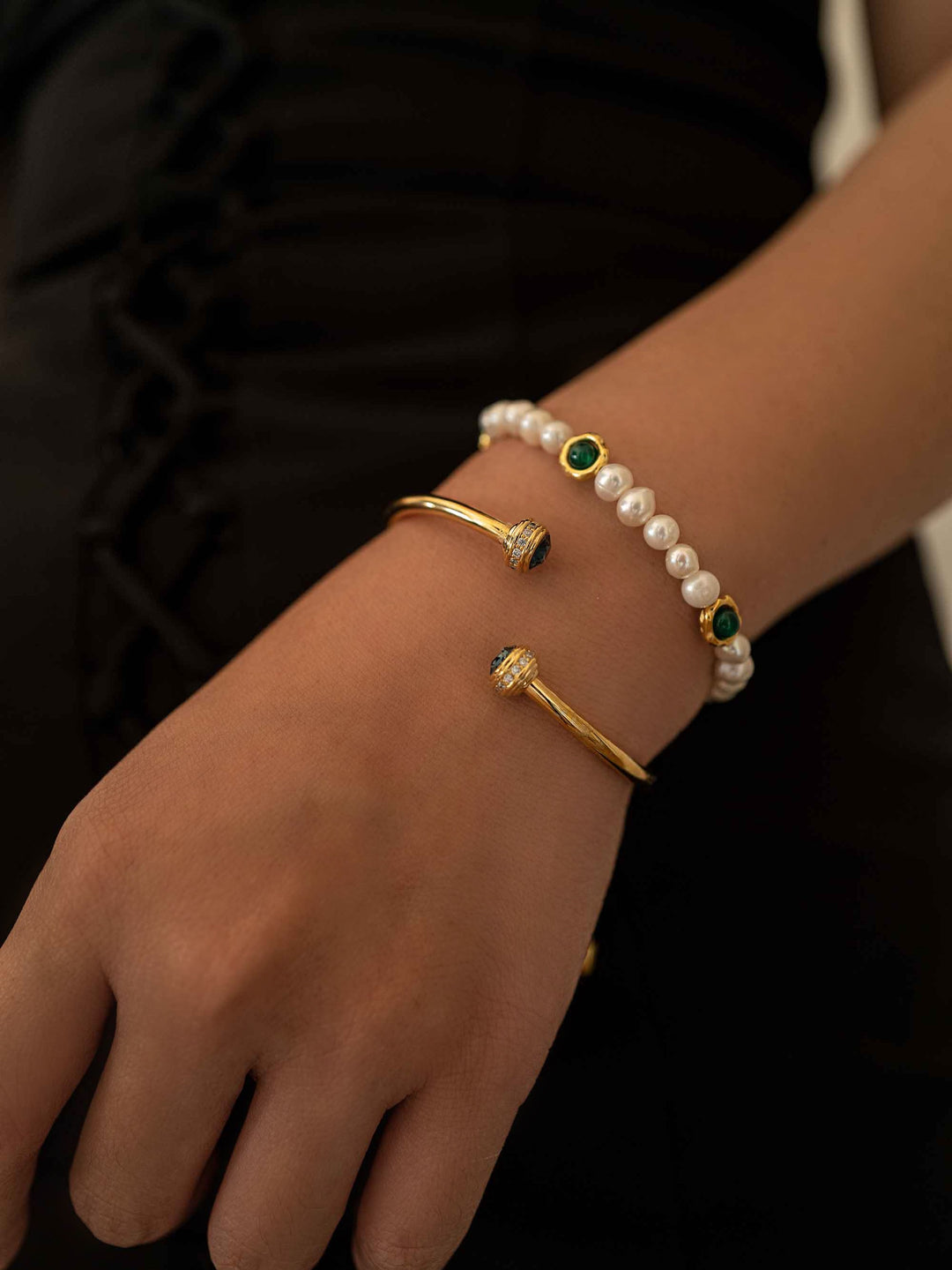 a hand with bracelets with blue stones and pearl