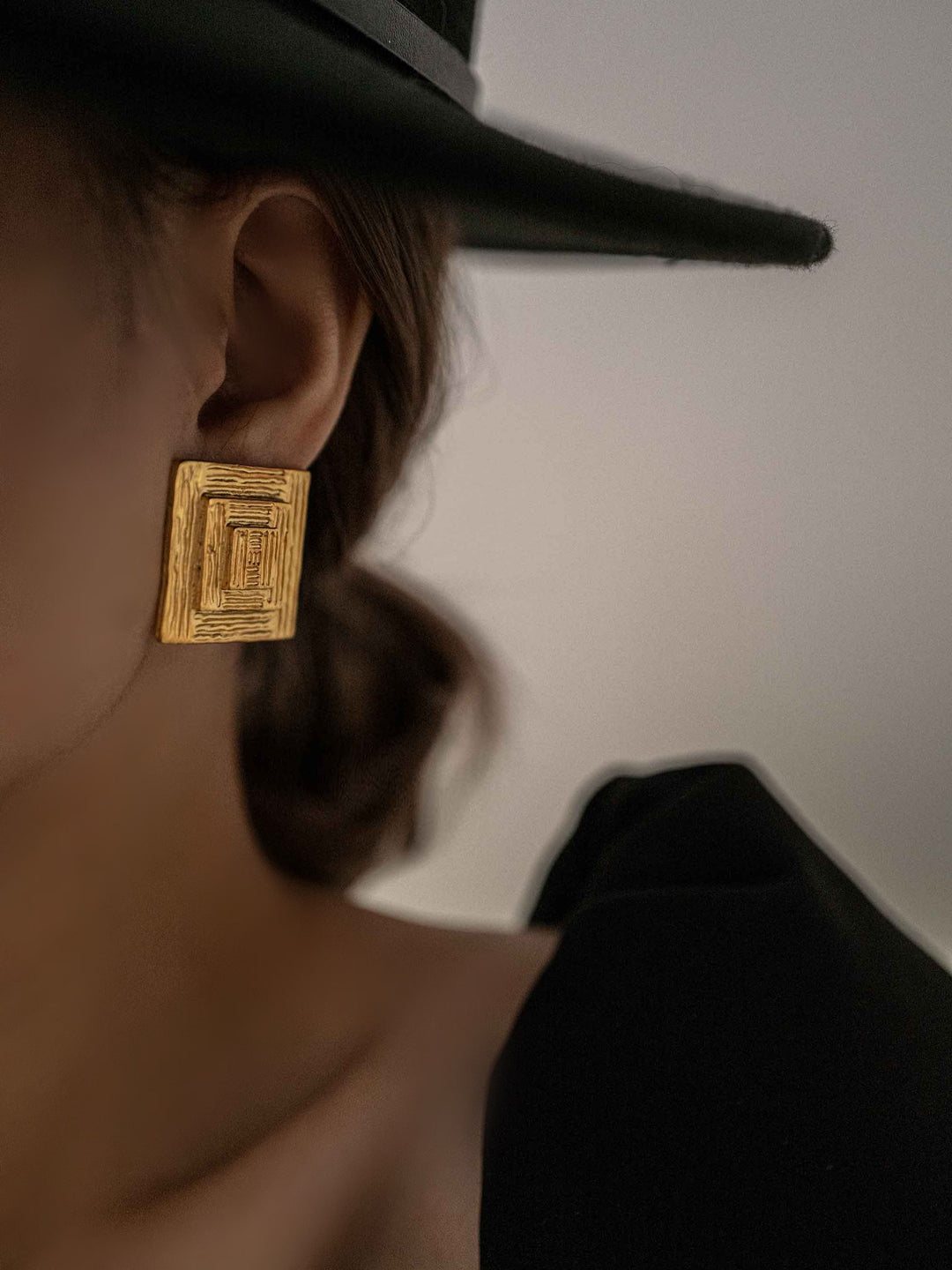 a model wear One square gold earring