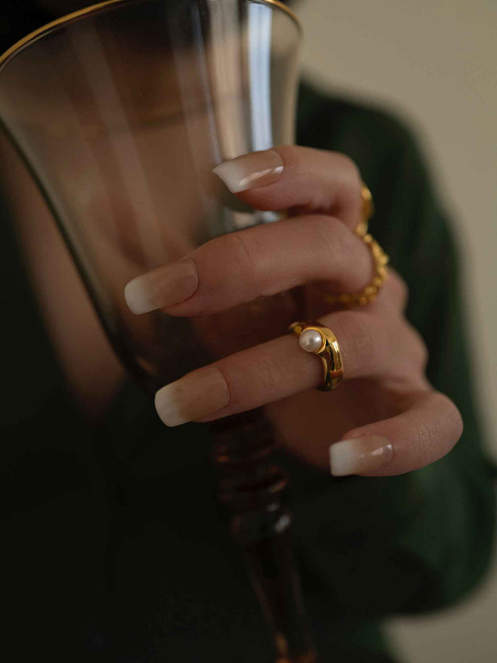 Una modelo con un anillo de oro engastado con una perla